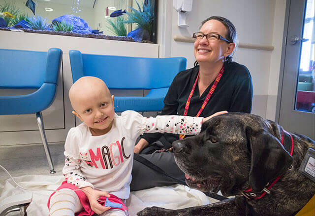 a child and doctor enjoy pet therapy